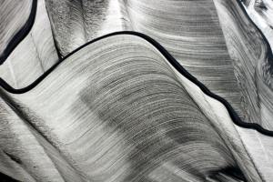 Artistic abstract image of black and white flowing lines, creating a dynamic and textured pattern.