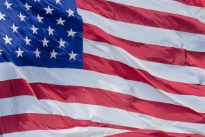 Vibrant American flag showing stars and stripes billowing in the breeze.